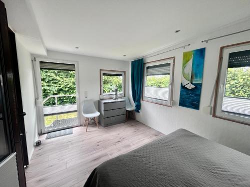 a bedroom with a bed and a desk and windows at FeWo-Krone in Heringsdorf
