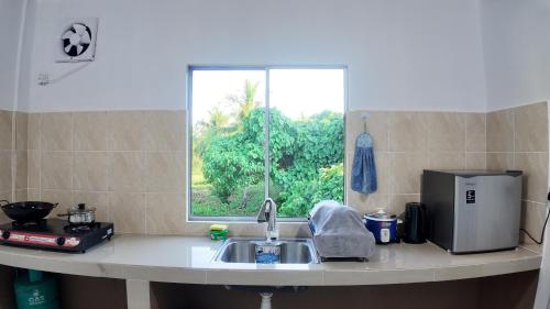 a kitchen counter with a sink and a window at F&D Homestay in Semporna