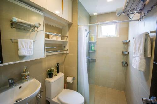 a bathroom with a toilet and a sink and a shower at Voice activated studio condo unit at One Regis Megaworld, JK Modern Nest in Bacolod
