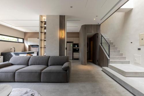 a living room with a couch and a staircase at 晴井villa in Huxi