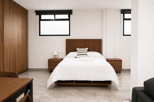 a bedroom with a bed and a couch and windows at Loft Ejecutivo San Martin Centro Wifi Tv 65 in San Martín Texmelucan de Labastida