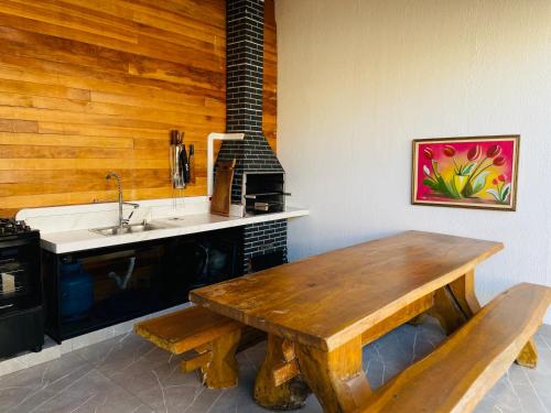 a kitchen with a wooden table and a sink at Unidades mobiliadas em condomínio in Lucas do Rio Verde