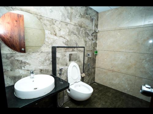a bathroom with a white toilet and a sink at S K Legacy Hotel in Mysore