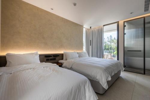 a hotel room with two beds and a large window at 晴井villa in Huxi