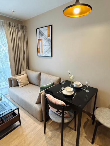a living room with a table and a couch at Tierra Residences in Bangkok
