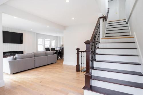 a living room with a staircase and a couch at Beautiful and Spacious 3BD Condo in Somerville in Somerville