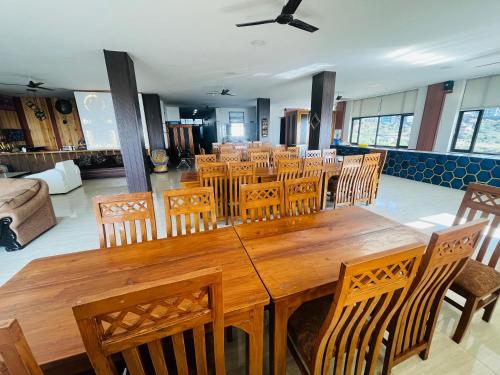 a dining room with a wooden table and chairs at HOTEL DEVDAR RESORT in Dharmsāla