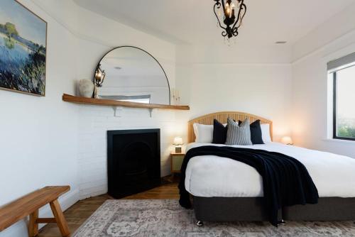 a bedroom with a bed and a fireplace at Garden Cottage, Wellness Studio & Bike Shed in Winnaleah