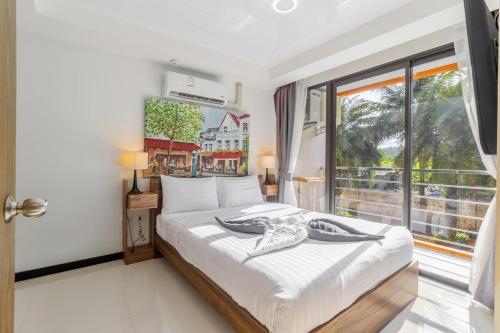 a bedroom with a bed and a large window at Beachside 1BR Condo Pool Gym Phuket- MBC C172 in Ban Bo Sai Klang