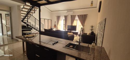 a kitchen with a sink and a living room at Villa Miradie in Grand-Bassam