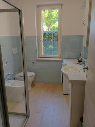 a bathroom with a sink and a toilet and a window at Casa Marina mare e relax in Marina Palmense