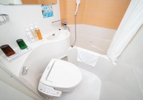 a white bathroom with a toilet and a sink at Super Hotel Minami Hikone Ekimae in Hikone