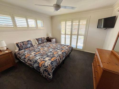 a bedroom with a bed and a ceiling fan at Jaspa - River Views - Bring your own linen in South West Rocks