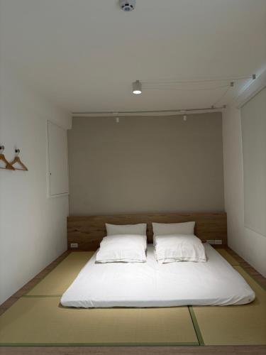 a bedroom with a white bed with two pillows at DayBreak 2 in Taitung City