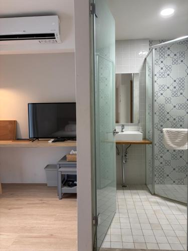 a bathroom with a glass shower and a sink at DayBreak 2 in Taitung City