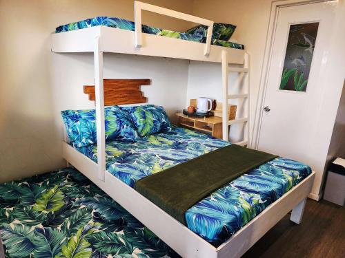 a bedroom with a bunk bed with blue and green sheets at Puffer Isle Resort in Dingalan
