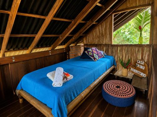 a bedroom with a bed with towels on it at El Bosque Minca in Minca