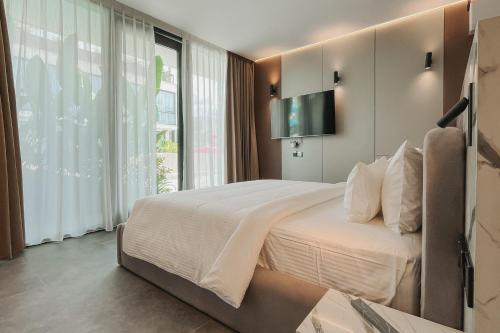 a bedroom with a large bed and a television at Awwa Boutique Hotel in Canggu