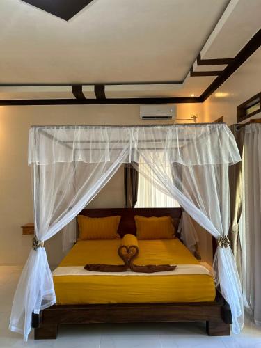 a bedroom with a bed with a canopy at Leuser Inn & Jungle Trekking in Bukit Lawang