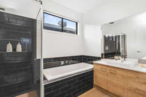 a bathroom with a tub and a sink and a mirror at Bayview Luxe- Sleeping 14, Pet Friendly, Views- 4 bedroom, lounge with sofa beds in Curlewis