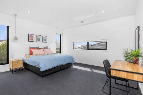 a bedroom with a bed and a table and some windows at Bayview Luxe- Sleeping 14, Pet Friendly, Views- 4 bedroom, lounge with sofa beds in Curlewis