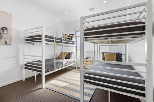 a bedroom with two bunk beds in a room at City & Surf Getaway in Grovedale