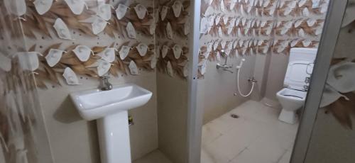 a bathroom with a sink and a toilet at Hotel relaxinn in Saharsa