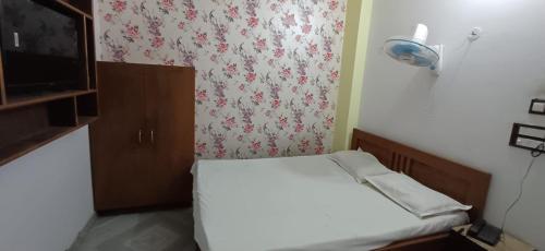 a small room with a small bed and a curtain at Hotel relaxinn in Saharsa