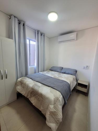 a bedroom with a bed in a white room at Casa Dunas - Las Caracolas - Cassino RS in Rio Grande