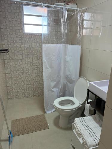 a bathroom with a toilet and a shower at Casa Dunas - Las Caracolas - Cassino RS in Rio Grande