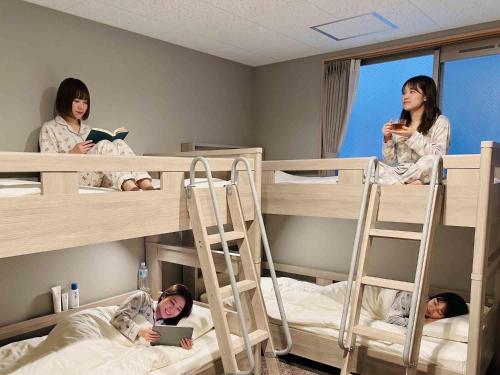 three girls in bunk beds in a room at BANDE Hotel in Namba in Osaka