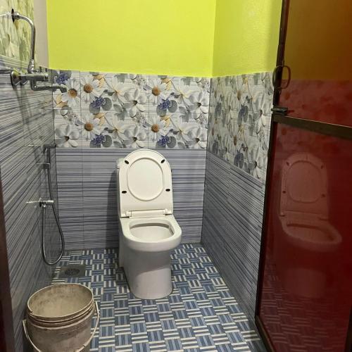 a bathroom with a toilet and a bucket in it at Briddhim Guest House in Syābru Bensi