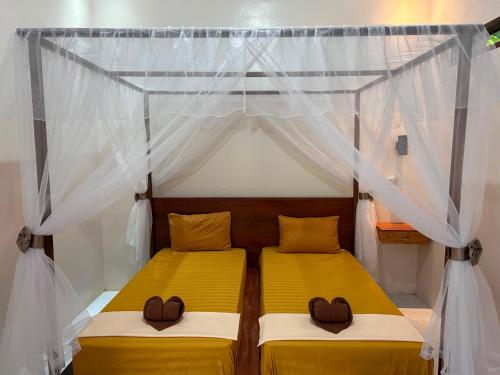 a bedroom with two beds in a tent at Leuser Inn & Jungle Trekking in Bukit Lawang