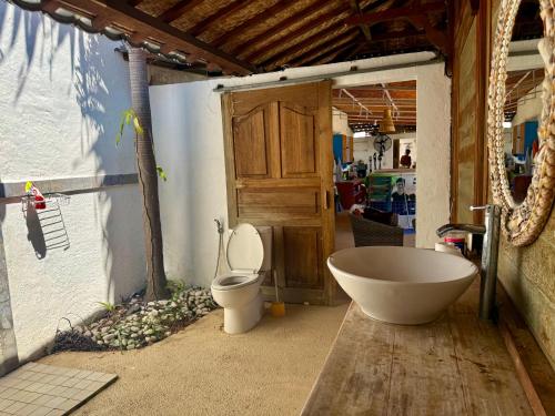 a bathroom with a bath tub and a toilet at Villa Bakso Mentigi in Teluknarat