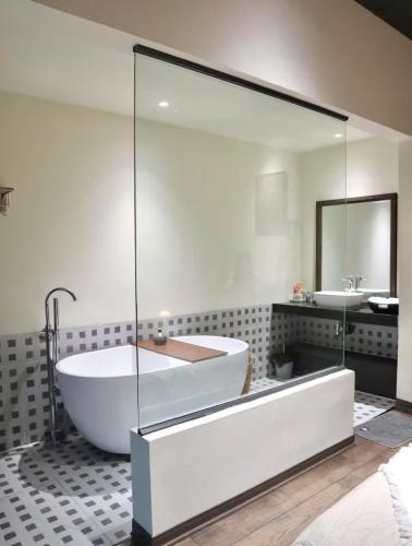 a large bathroom with a tub and a mirror at Casa de Holu Homestay in Ða Gia