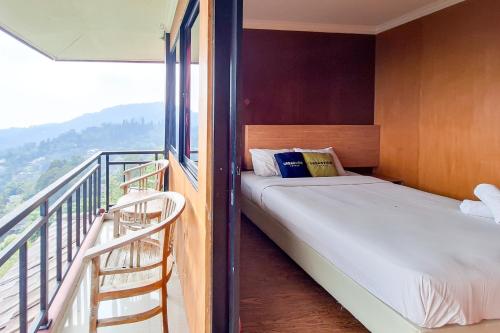 a small bedroom with a bed and a balcony at Urbanview Hotel Salakview Megamendung in Pondok Cipaseban