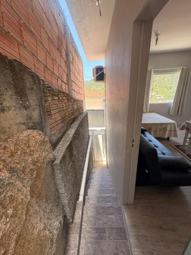 a room with a brick wall and a couch against a wall at Kit Net in Governador Celso Ramos
