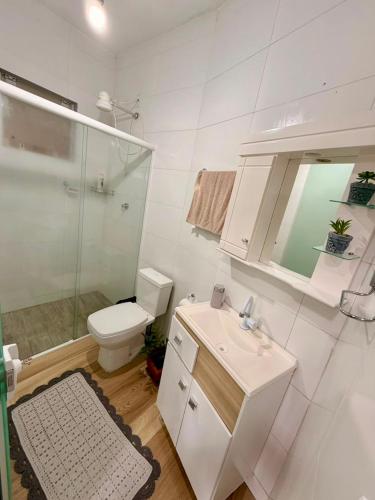 a bathroom with a toilet and a sink and a shower at Kit Net in Governador Celso Ramos