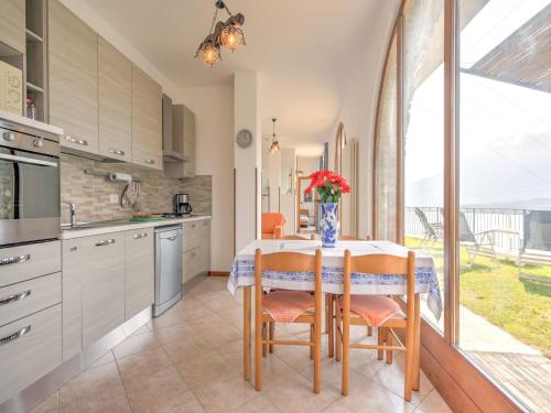 a kitchen with a table with a vase of flowers on it at Wonderful flat with swimming pool, lift and garden in Gravedona