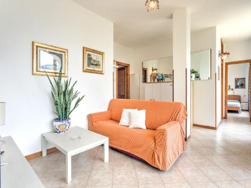 a living room with an orange couch and a table at Wonderful flat with swimming pool, lift and garden in Gravedona