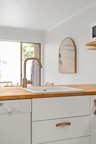 a kitchen counter with a sink and a window at Beach Street - Town Location - Stone Real Estate Yamba in Yamba