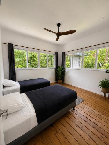 a bedroom with two beds and a ceiling fan at Spot on Drago in Bocas Town
