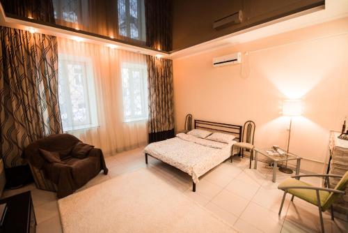 Un dormitorio con una cama, una silla y una lámpara. en Studio Ember at Maidan Konstytutsii, en Járkov