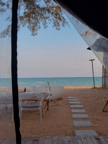 a group of chairs and a boat on the beach at Coody Seastar in Ban U Taphao