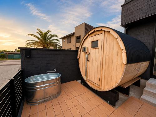 a wooden tub sitting on the side of a house at Coco Resort Futtsu in Futtsu