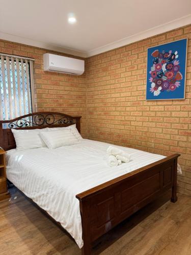 a bed in a room with a brick wall at Entire 2 bedrooms unit in Geraldton