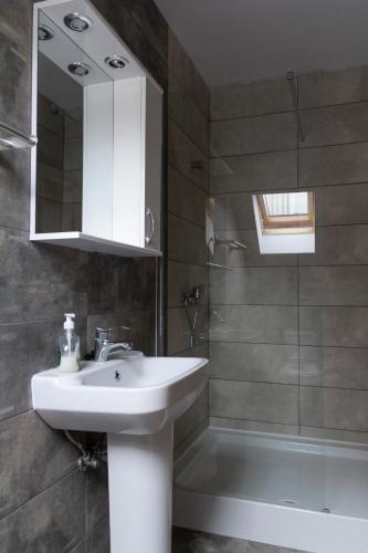a bathroom with a sink and a shower at Casa Róza Vendégház in Sfântu-Gheorghe