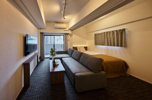 a living room with a couch and a bed at Grand Residence Hotel Hakata Premier in Fukuoka