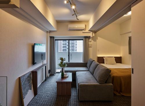 a living room with a couch and a bed at Grand Residence Hotel Hakata Premier in Fukuoka