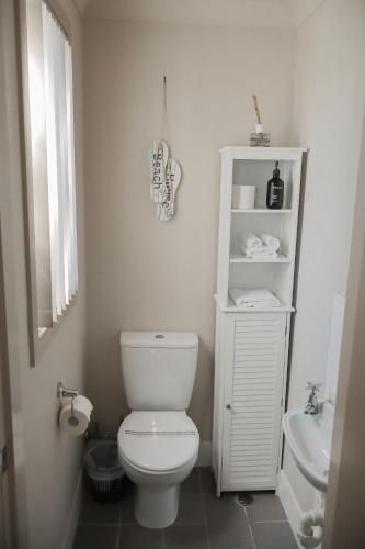 a bathroom with a white toilet and a sink at Seaspray 8 - Ocean Views - Stone Real Estate Yamba in Yamba